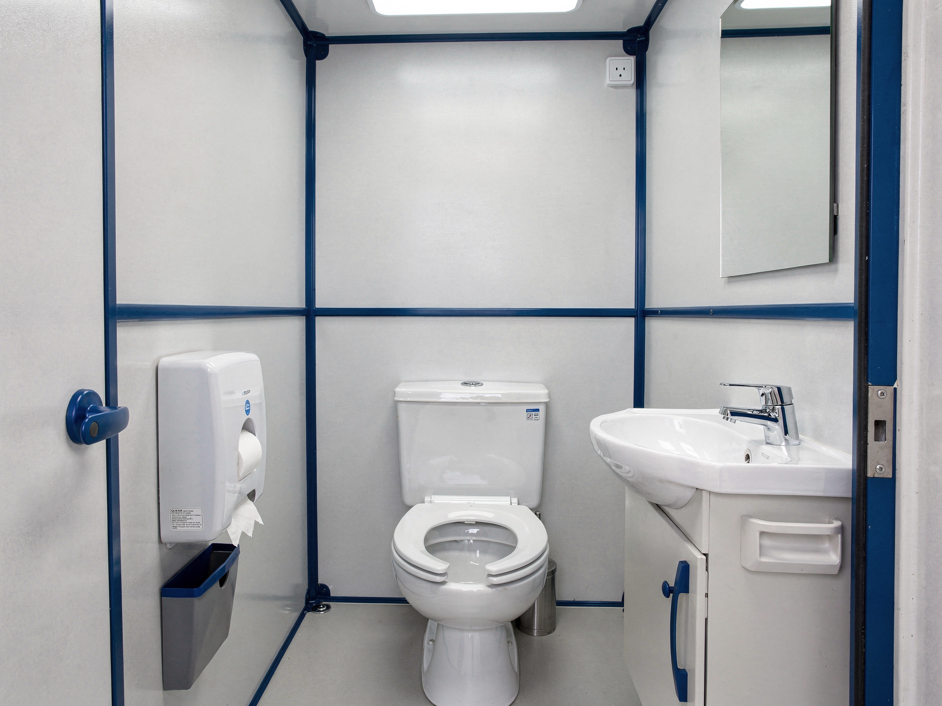 Interior of a modern deluxe flushing portable toilet with sink and mirror